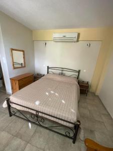 a bedroom with a bed and a air conditioner at Vasilikos Apartments in Paralia Agias Foteinis