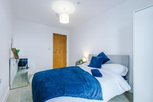 a bedroom with a blue blanket on a bed at Stunning Salford Quays 2Bed, Amazing Views, Parking Available, Free WI-FI, Great Transport Links, Smart TVs, Long Term Disc in Manchester