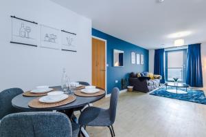a dining room and living room with a table and chairs at Stunning Salford Quays 2Bed, Amazing Views, Parking Available, Free WI-FI, Great Transport Links, Smart TVs, Long Term Disc in Manchester