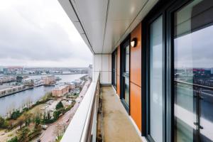 a balcony of a building with a view of a river at Stunning Salford Quays 2Bed, Amazing Views, Parking Available, Free WI-FI, Great Transport Links, Smart TVs, Long Term Disc in Manchester