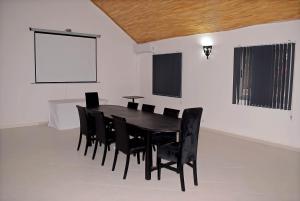 ein Esszimmer mit einem schwarzen Tisch und schwarzen Stühlen in der Unterkunft Chez Doki Sen hôtel in Sali Nianiaral