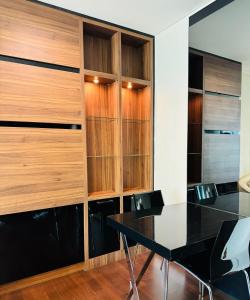 a dining room with a black table and wooden cabinets at Ivy Thonglor in Khlong Toei