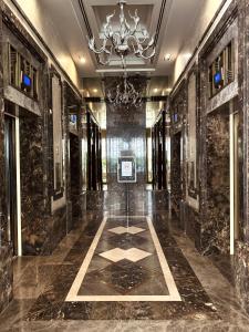 a hallway with black marble walls and a chandelier at Ivy Thonglor in Khlong Toei