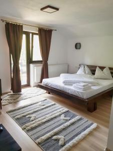 a bedroom with a bed and a large window at CABANA FRAM VÂRTOP in Nucet