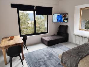 a bedroom with a bed and a desk and a chair at Vila Plava Zlatar in Brdo