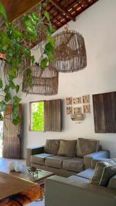 ein Wohnzimmer mit Sofa und einigen Pflanzen in der Unterkunft A Casa de Ponta in Maragogi