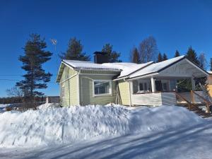 a house in the snow with a pile of snow at Villa Lumia in Paranen