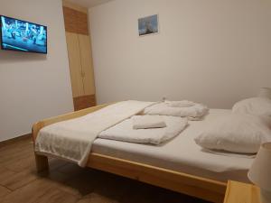 uma cama com lençóis brancos e almofadas em Potyka Apartman em Tiszafüred