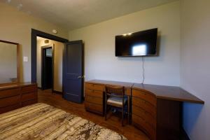 a room with a desk with a television on the wall at Comfortable and close in to MU and Downtown in Columbia
