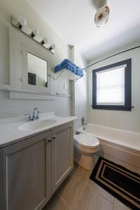 a bathroom with a sink and a toilet and a mirror at Comfortable and close in to MU and Downtown in Columbia