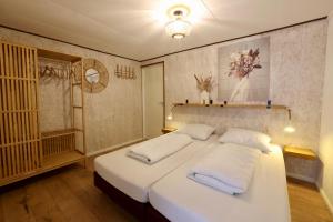 een slaapkamer met een groot wit bed met 2 kussens bij Dubbelduyn vakantie boerderij Callantsoog in Callantsoog