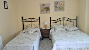 1 dormitorio con 2 camas y mesa con lámpara en Casa del Molinero en Río Mundo, Molino Pataslargas, en Cotillas