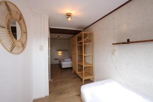 a room with a bed and a room with a mirror at Dubbelduyn vakantie boerderij Callantsoog in Callantsoog