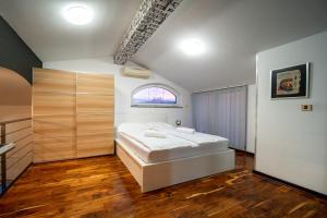 a bedroom with a white bed and a window at Šanić Apartments 543/a in Lopar