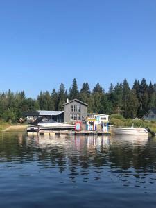 um par de barcos ancorados numa doca num lago em Lägenhet med sjötomt. Vildmark i tätort. em Umeå