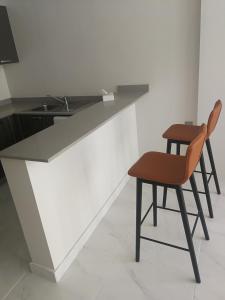 a kitchen with a counter with a chair and a table at Infinity Juffair Suites in Juffair