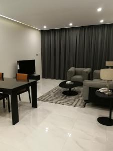 sala de estar con sofá, mesa y sillas en Infinity Juffair Suites, en Juffair