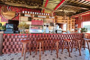 un bar con taburetes de madera en un restaurante en Auguri Home & Crafters en Kon Von Kla