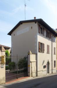 a white building with a gate on a street at Palazzina Gelsomino in Desenzano del Garda