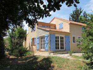 ein großes Haus mit blauen Fensterläden darauf in der Unterkunft Villa romantique avec Poolhaus in Cotignac