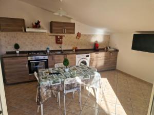 a kitchen with a table with chairs and a sink at PANORAMIC HOUSE -Santa Teresa di Riva- BANDIERA BLU in Santa Teresa di Riva +6 photos