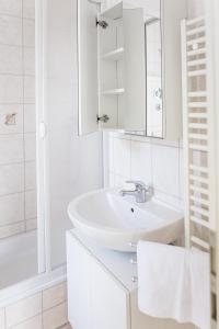 a white bathroom with a sink and a mirror at Villa Aida in Ahlbeck