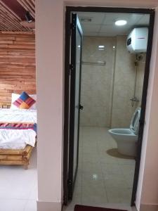 a bathroom with a shower and a toilet and a bed at Sapa indigo inn in Sapa