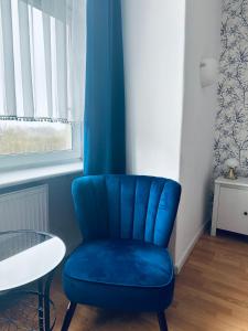 a blue chair in a room with a table at Hostel Octopus Gdańsk in Gdańsk