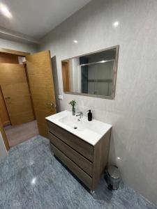 La salle de bains est pourvue d'un lavabo et d'un miroir. dans l'établissement Mingos, à Arzúa