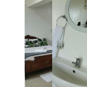 a bathroom with a sink and a mirror and a bed at Millan Homes in Mombasa
