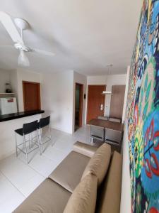 a living room with a couch and a kitchen at Flat Veredas Rio Quente-GO in Rio Quente