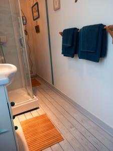 a bathroom with a shower and a wooden floor at Chambre d'hôte & coin petit-déjeuner in Camaret-sur-Mer