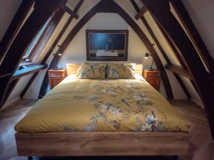 a bed with a yellow comforter in a attic at Keizersgracht Centre in Amsterdam