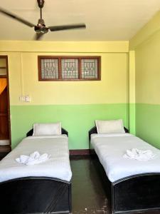 two beds in a room with green walls at Metro Eco Hotel in Kathmandu