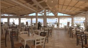 un ristorante con tavoli e sedie bianchi e l'oceano di La mia terrazza sul mare - Mared'aMare a Bari