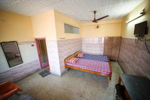 um quarto com uma cama no canto de um quarto em Sri sai baba guest house em Pondicherry