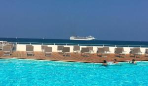 una piscina con sedie e una nave da crociera in acqua di La mia terrazza sul mare - Mared'aMare a Bari