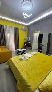 ein Schlafzimmer mit einem großen gelben Bett und einem Sofa in der Unterkunft Algen Room's in Berat