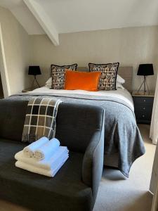 a bedroom with a bed and a couch with towels at Bramwood Guest House in Pickering