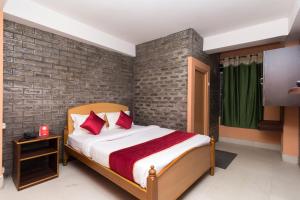 a bedroom with a bed and a brick wall at OYO Flagship Balaji Guest House in Shillong