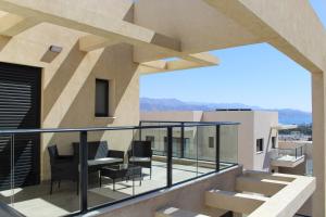 a balcony with chairs and tables on a building at Penthouse #47 By Hashdera Eilat in Eilat