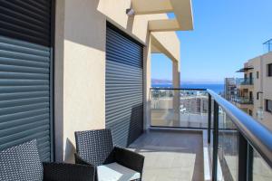 a balcony with two chairs and a view of the ocean at Penthouse #47 By Hashdera Eilat in Eilat