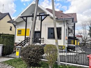 una casa bianca con una recinzione di fronte di Kimanoclegi a Opole