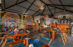 a dining room with wooden tables and a colorful wall at Simroseate in Agonda