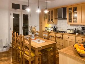 uma cozinha com uma mesa de madeira e cadeiras de madeira em Four-tunes em Torquay