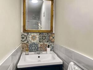uma casa de banho com um lavatório e um espelho em Four-tunes em Torquay