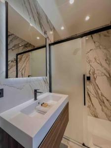 ein Badezimmer mit einem weißen Waschbecken und einem Spiegel in der Unterkunft Cannes - Luxury Apartment straight La Croisette 6Pers in Cannes