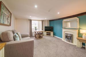 a living room with a couch and a fireplace at Library View Apartment in Kendal
