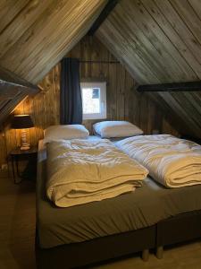 two beds in a room with a attic at gezellige cottage in zeeland in Sint Annaland