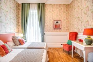 ローマにあるMangili Garden Hotelのベッド、デスク、窓が備わるホテルルームです。